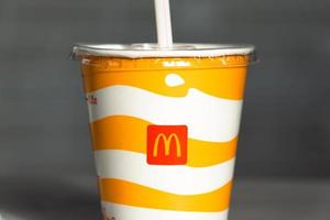 A glass with a milkshake or a cold drink with a McDonald's logo close-up. Fast food restaurant chains. Russia, Kaluga, March 21, 2022. photo