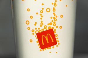 A glass with a milkshake or a cold drink with a McDonald's logo close-up. Fast food restaurant chains. Russia, Kaluga, March 21, 2022. photo