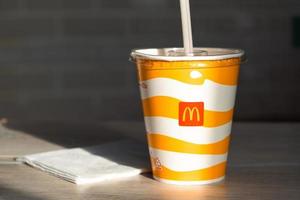 A glass with a milkshake or a cold drink with a McDonald's logo close-up. Fast food restaurant chains. Russia, Kaluga, March 21, 2022. photo