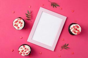 Red velvet cupcakes for Valentines Day in bright pink setting photo