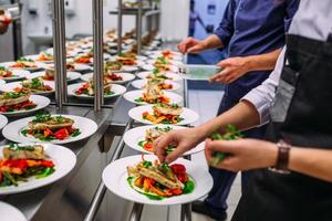 Meat dish with vegetables for catering. Lots of plates. photo