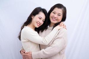 Portrait of Asian mother and daughter on white background photo