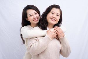 Portrait of Asian mother and daughter on white background photo