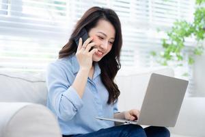 Young Asian businesswoman working at home with her dog photo