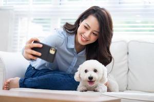 Young Asian woman playing with dog at home photo