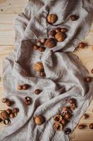 Hot cocoa with cookies, cinnamon sticks, anise, nuts on wooden background. Front view, copy space.