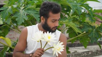 un hombre con flores blancas foto