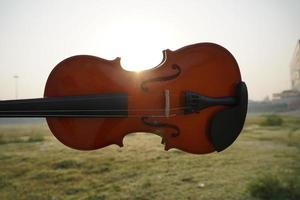 primer plano de violín en mano con efecto de luz solar foto