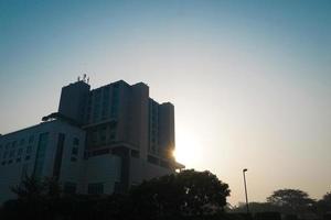 Modern glass building with reflected evening city and sunset sky in it. photo