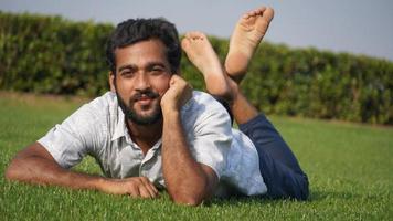 man in grass and smiling photo