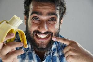 man eating banana and showing teeth photo