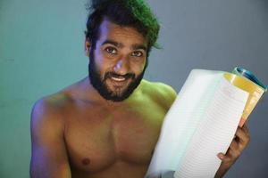 young man with book smiling face without cloths studio shot photo