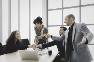 Smiling businesswoman handshake celebrate success or acheivement with team,Teamwork unity concept photo