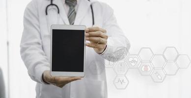 Doctor hold digital tablet with blank screen in hospital with infographic and copy space
