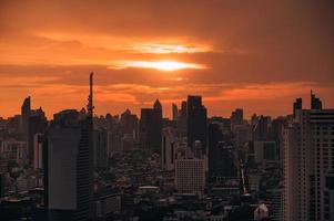 amanecer sobre un edificio de oficinas de gran altura en el distrito de negocios de bangkok foto