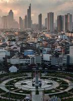 monumento de la rotonda de wongwianyai con residencia coronada y rascacielos en el centro de bangkok foto