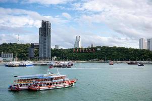 Scenery of Pattaya beach with building and ferry port in tropical sea photo