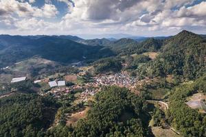 Aerial view of local village in the valley among tropical rainforest at countryside photo