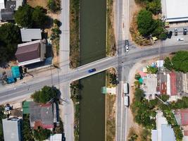 tráfico en la carretera de intersección a través del puente sobre el canal en el pueblo rural foto