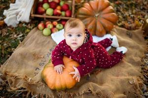 la niña se apoya en una calabaza. foto