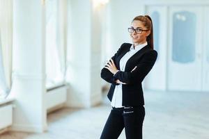 Happy business woman looking confident with modern building as b photo