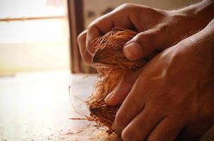 man peeling coconut from hand image indoor shoot photo