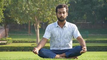 man doing meditation in park in office hours photo