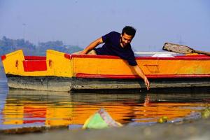 el hombre disfruta con agua sentado en el bote foto