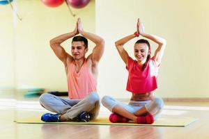 Young man and woman doing yoga. Lotus pose meditation