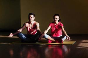 Young man and woman doing yoga. Lotus pose meditation photo