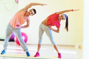 two young people in the gym doing exercises for fitness photo