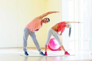 two young people in the gym doing exercises for fitness photo