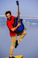 Man playing acoustic guitar on the boat. photo