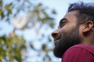 Half-turned side profile close up view portrait of handsome virile masculine attractive confident smart intelligent clever indian man photo