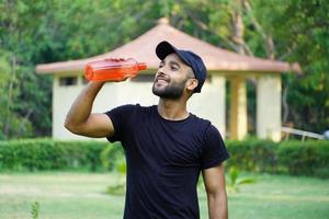 a man drinking water in park photo