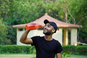 a man drinking water in park photo