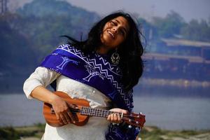 Women playing ukulele guitar in farm photo