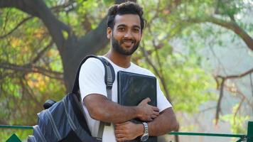 alegre joven estudiante con laptop mirando foto