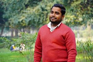 Young man giving a smile standing at park at morning work photo