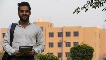 joven estudiante universitario parado fuera del collage - joven estudiante feliz y sonriente foto