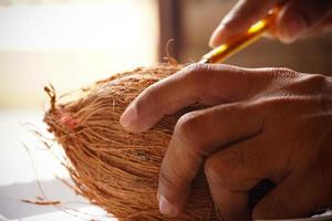 man peeling coconut from hand image indoor shoot photo