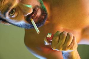 man smoking with cigarette and lighter photo