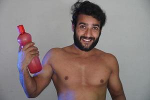 a healthy man with water bottle without cloths studio shot photo