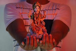 a man holds goddess laxmi satute photo