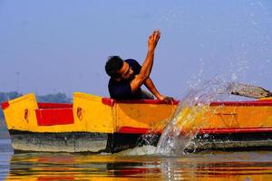 man enjoy with water sitting in the boat photo
