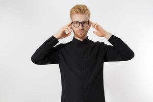 Young man in thinking process. Close up redheaded guy with red beard in black shirt, glasses focus on creating startup idea isolated on gray background. Intellect mind and brain power. Mental health. photo