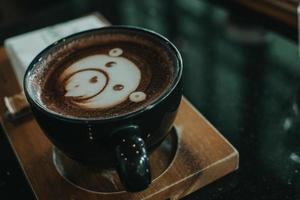 a cup of coffee latte art on wood table - Image photo