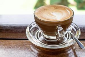 café capuchino en una mesa de madera antigua y granos de café tostados - imagen foto