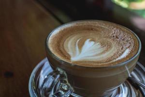 café capuchino en una mesa de madera antigua y granos de café tostados - imagen foto