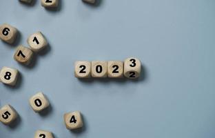 Wooden cube block flipping from 2022 to 2023 on blue background , preparation for merry Christmas and happy new yea concept. photo